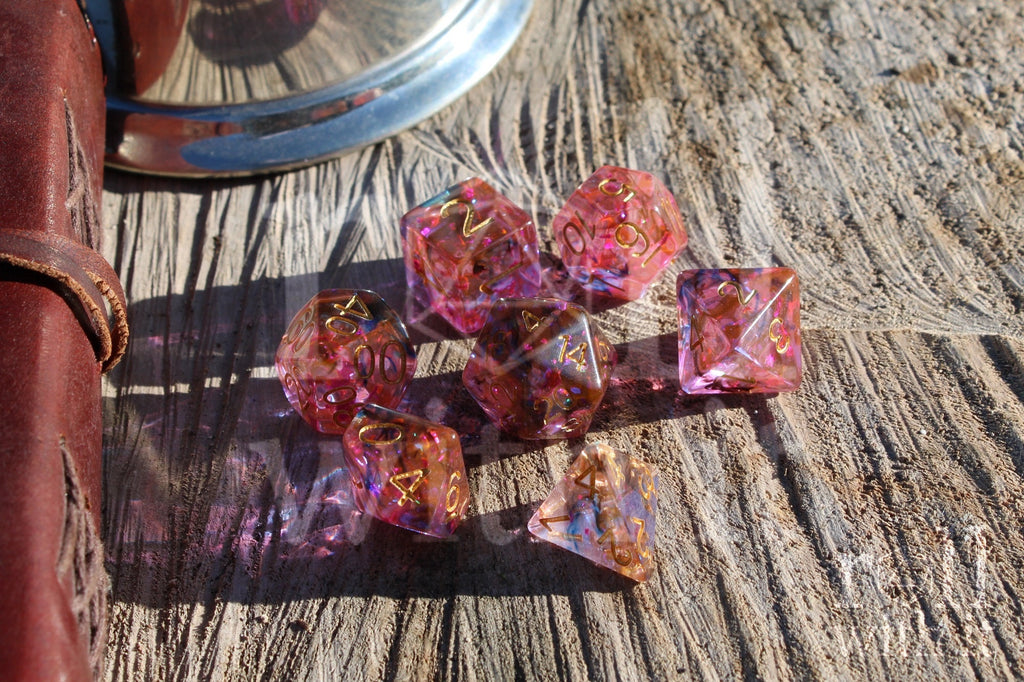 Set of colourful purple and swirling black and orange polyhedral dice on a wooden surface