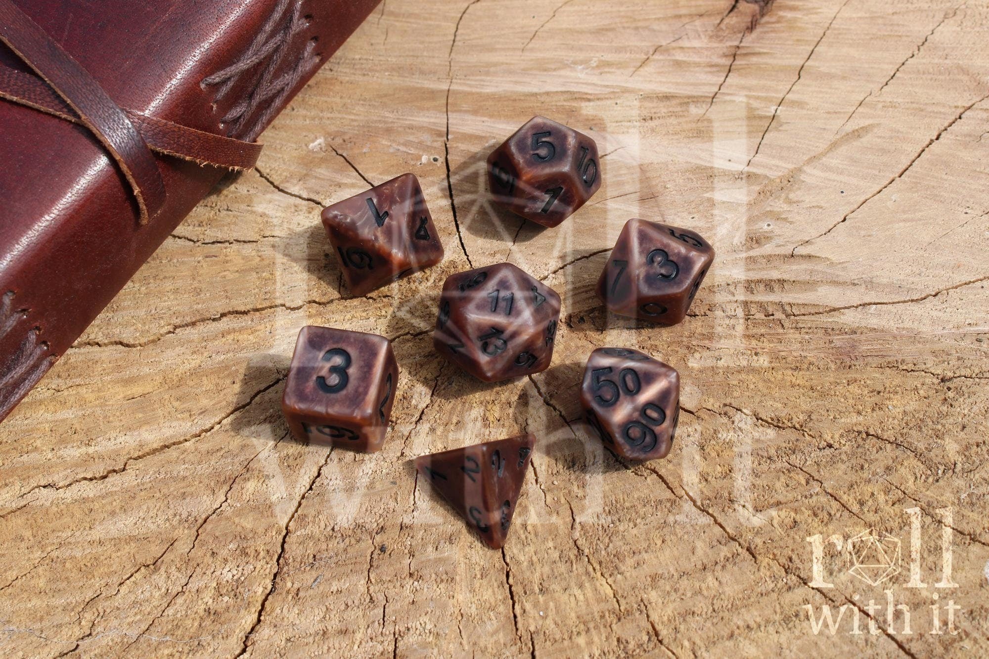 Set of bronze copper matte and worn looking polyhedral DnD dice with black numbers on a wooden surface