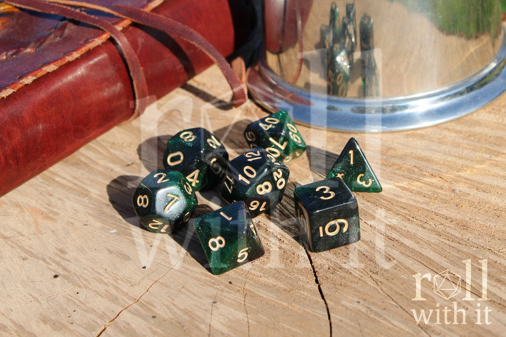 Set of starry green glittery polyhedral DND dice with gold numbers on a wooden surface