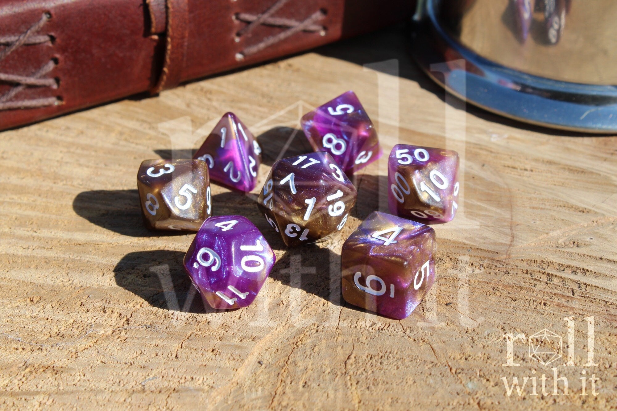 Purple and gold polyhedral DND dice with white numbers on a wooden surface