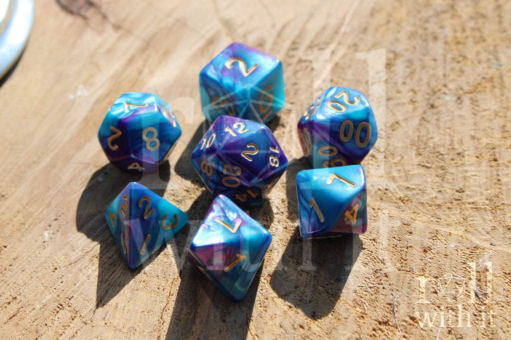 A set of colorful purple and blue polyhedral dice with golden numbers on a wooden surface