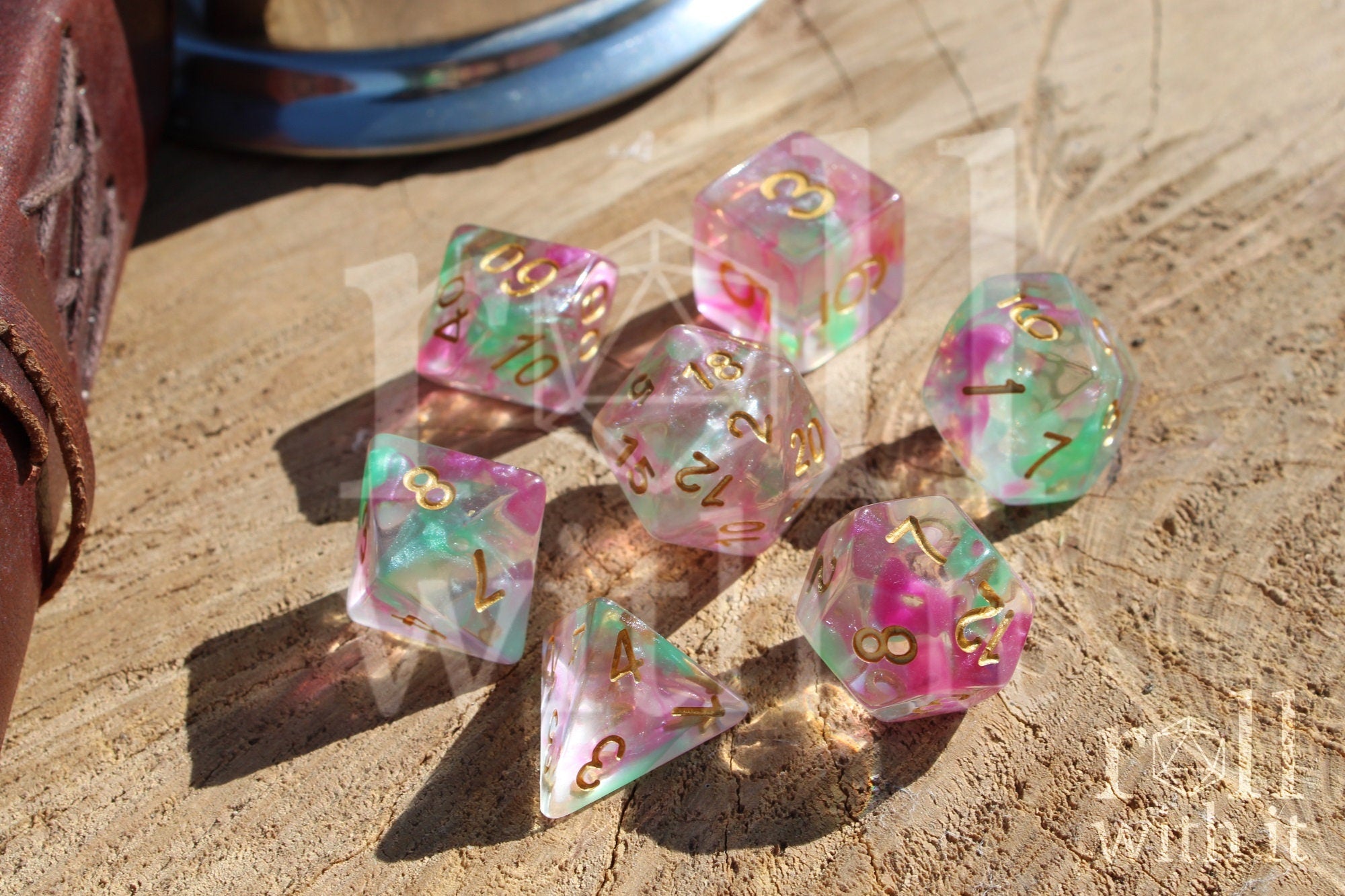 Set of purple and green clear dice with gold numbers on a wooden surface