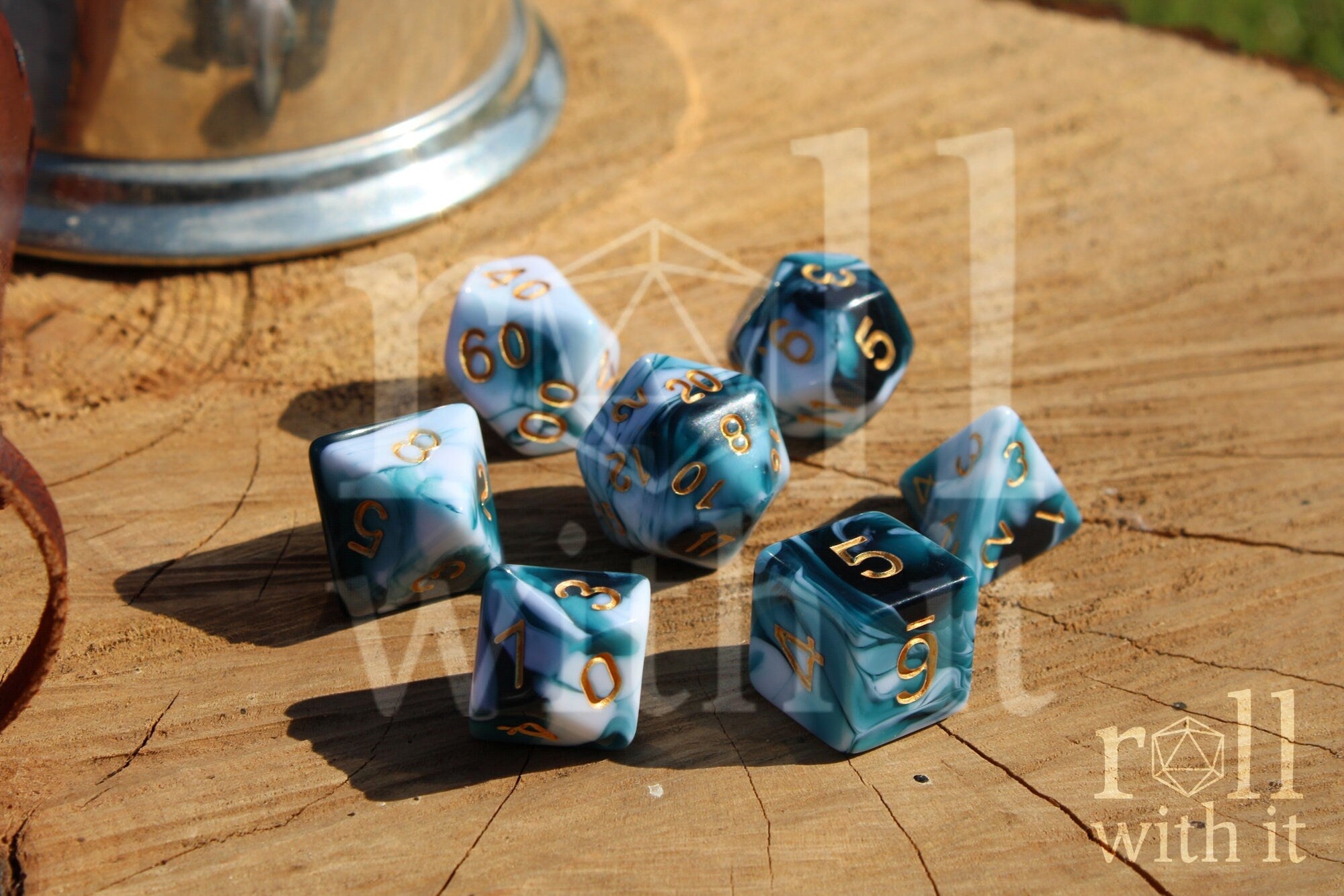 Set of swirling white and blue roleplaying dice with gold numbers on a wooden surface