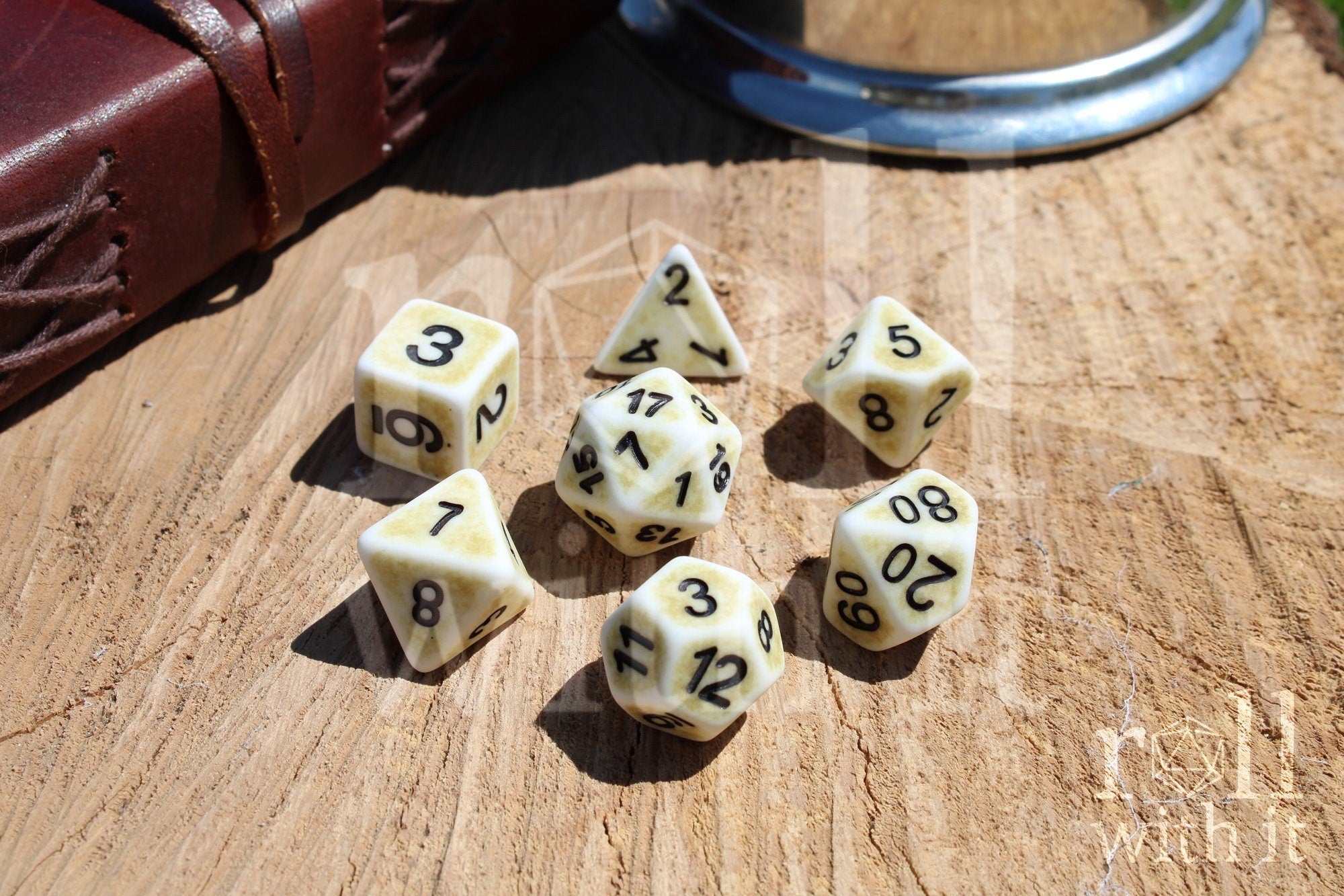 Set of creamy bone white matte dice with black numbers on a wooden surface