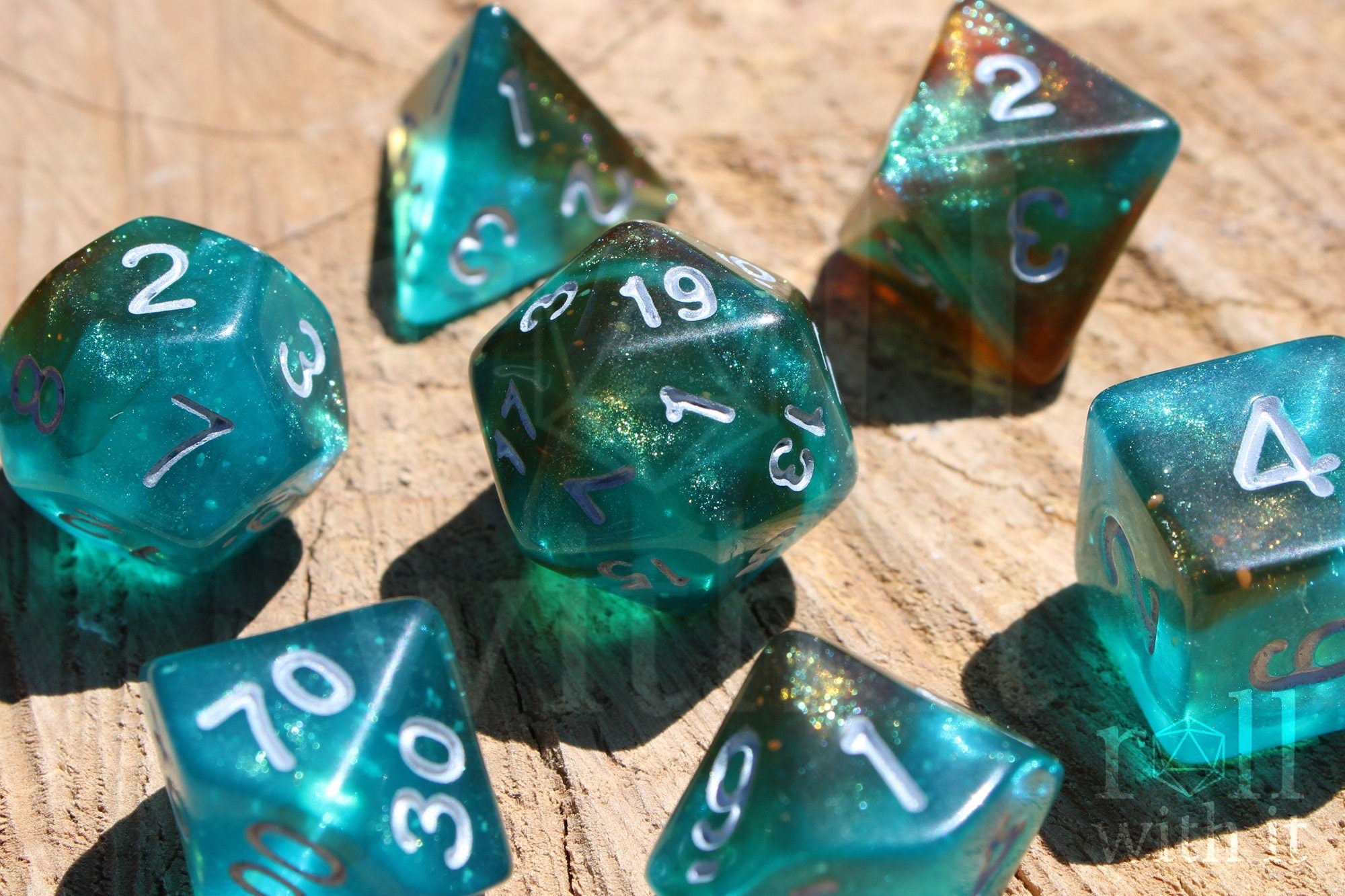 Set of turquoise blue and copper glittery polyhedral dice with white numbers on a wooden surface