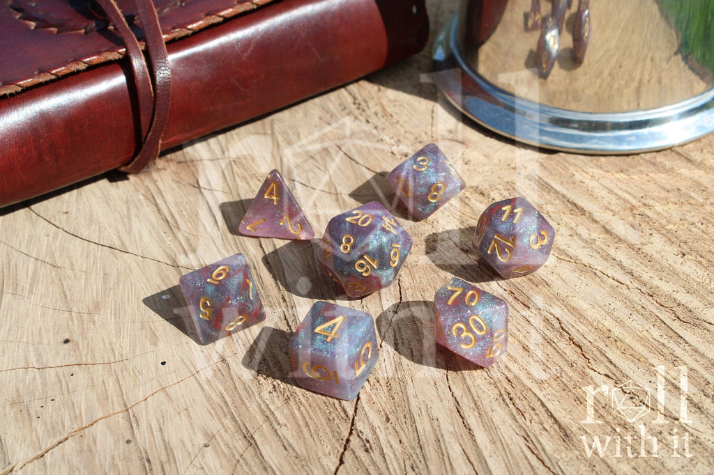 Set of glittery star like purple and blue polyhedral dice on a wooden surface