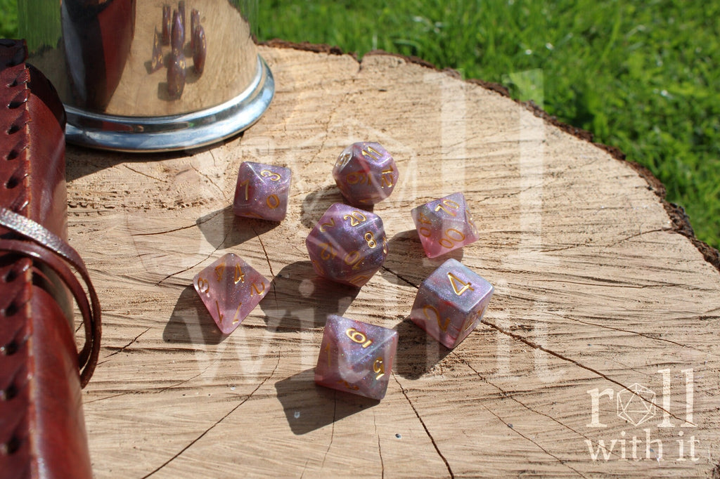Set of glittery star like purple and blue polyhedral dice on a wooden surface