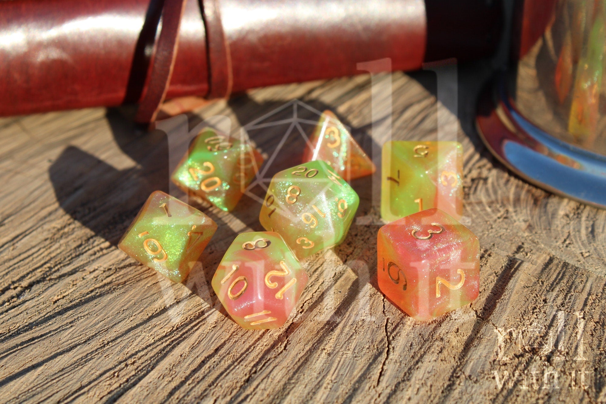 Set of colourful glittery light green and peachy pink polyhedral dice on a wooden surface