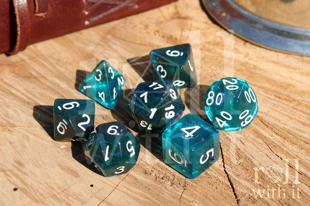 Set of 7 teal and black polyhedral roleplaying dice with lilac glitter set on a wooden surface