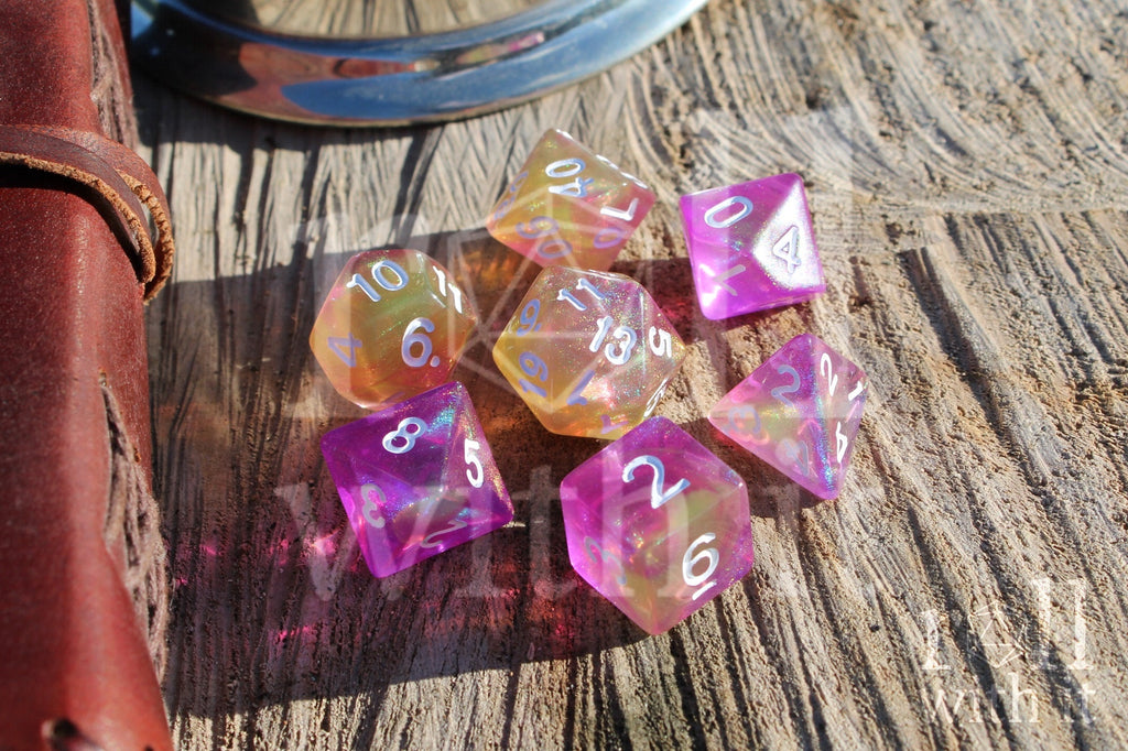 Set of colourful purple pink and yellow glittery tabletop RPG polyhedral dice on a wooden surface