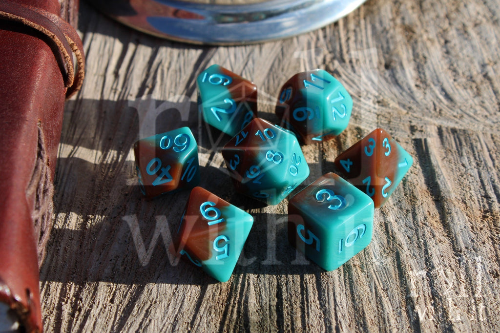 Set of turquoise blue and chocolate brown polyhedral dice on a wooden surface