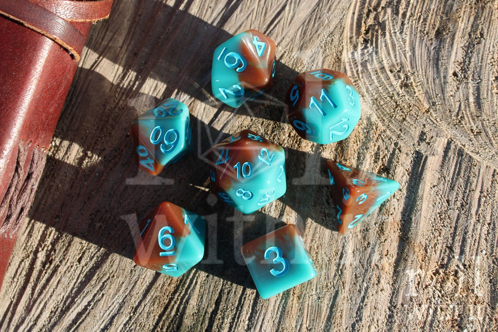 Set of turquoise blue and chocolate brown polyhedral role playing dice on a wooden surface