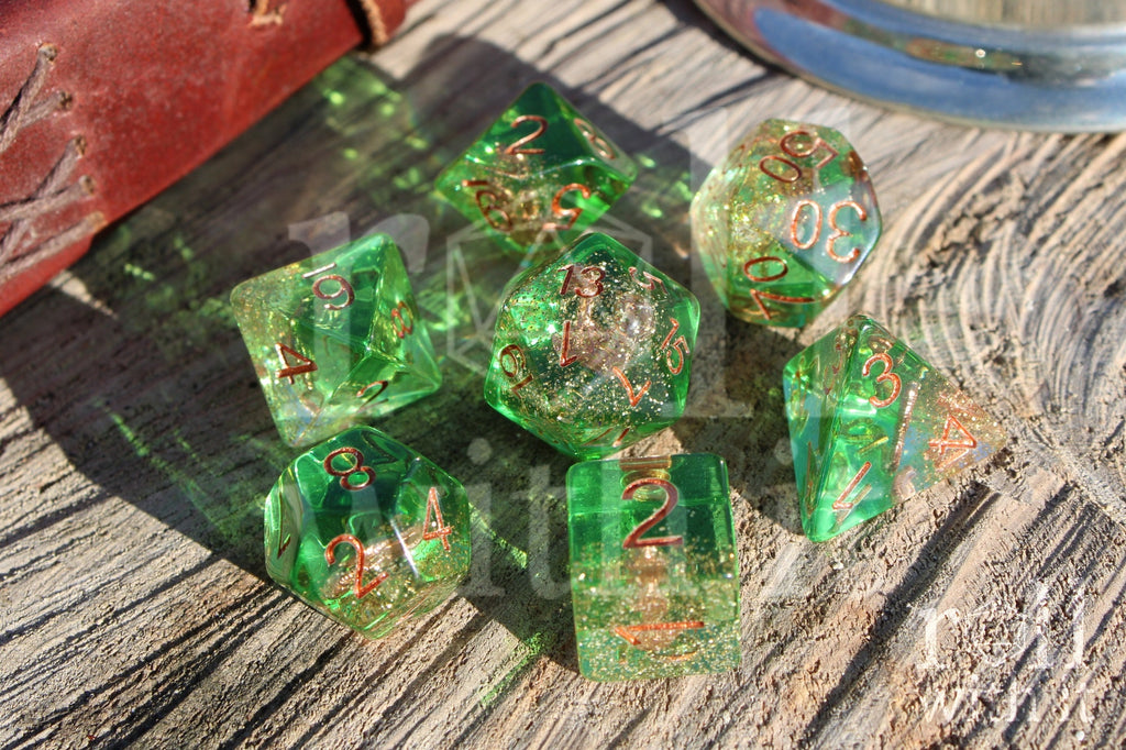 Set of green golden glittery dice with an anchor inside polyhedral dice with copper numbers on a wooden surface