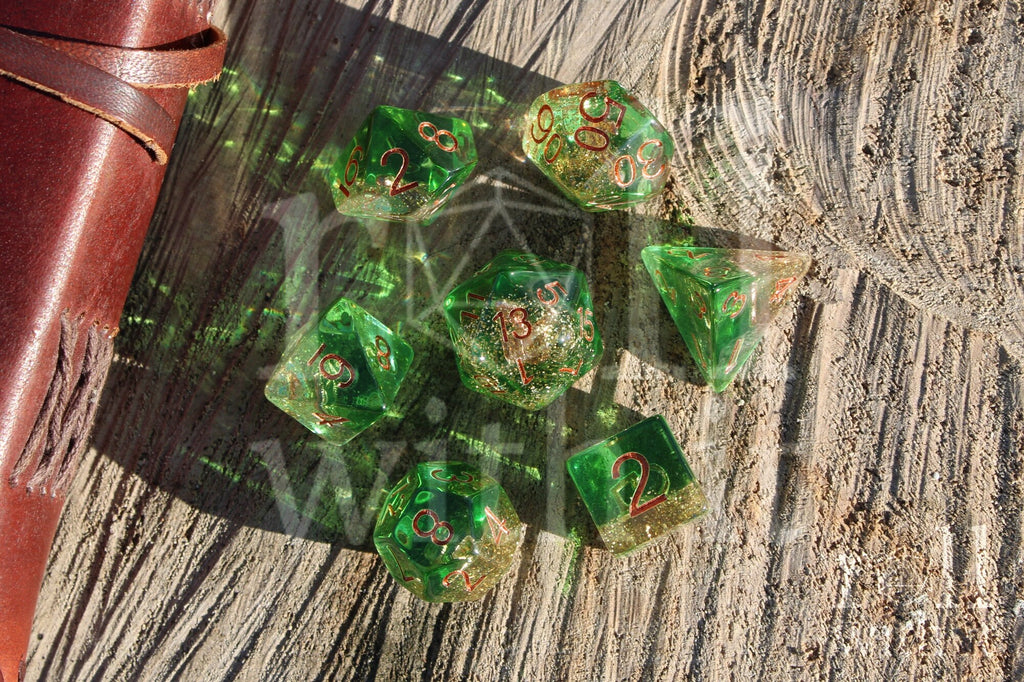 Set of green golden glittery dice with an anchor inside polyhedral dice with copper numbers on a wooden surface