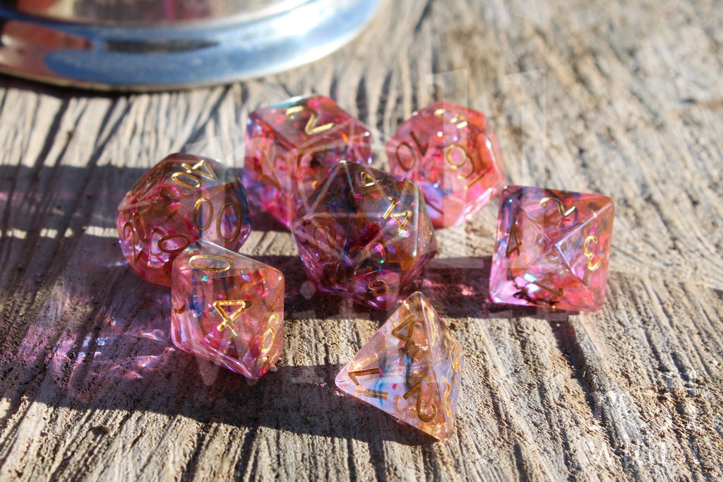 Set of colourful purple and swirling black and orange polyhedral dice on a wooden surface