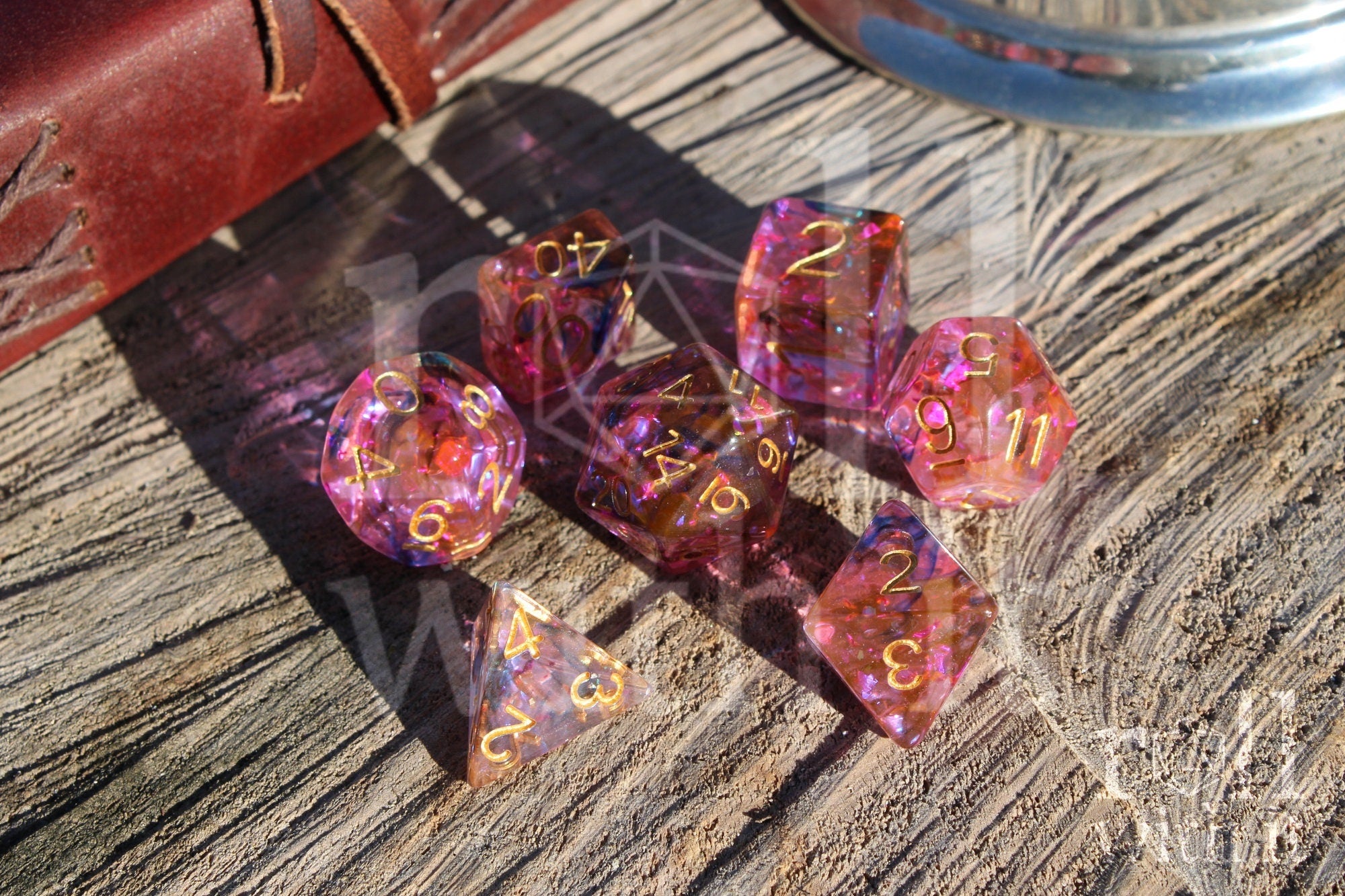 Set of colourful purple and swirling black and orange polyhedral dice on a wooden surface