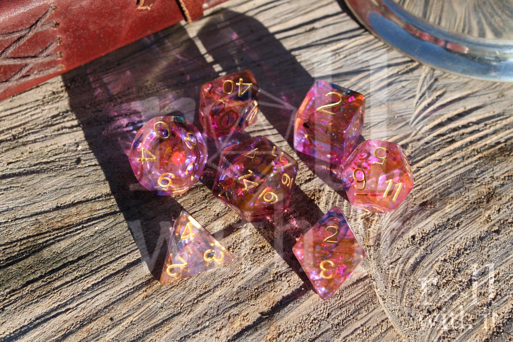 Set of colourful purple and swirling black and orange polyhedral dice on a wooden surface