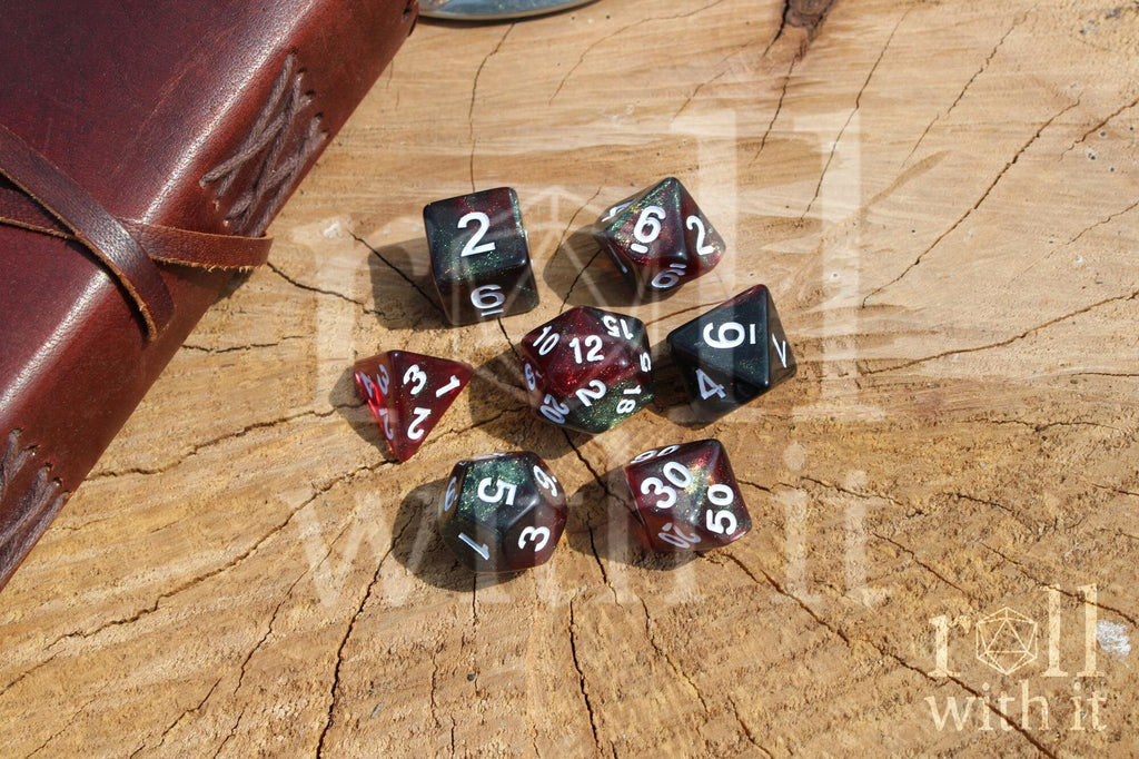 Set of glittery and star like black and red polyhedral dice with a green shimmer on a wooden surface