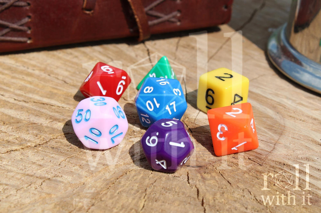 A colourful rainbow polyhedral set of dice with white, blue, and black numbers on a wooden surface