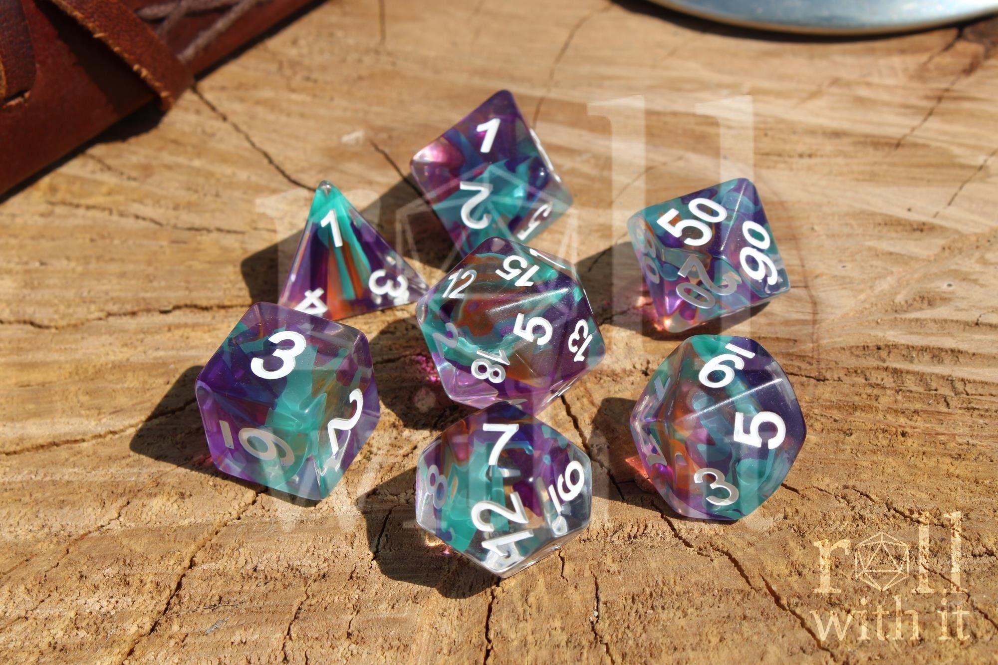 Set of colourful blue toned multicoloured polyhedral DND dice on a wooden surface