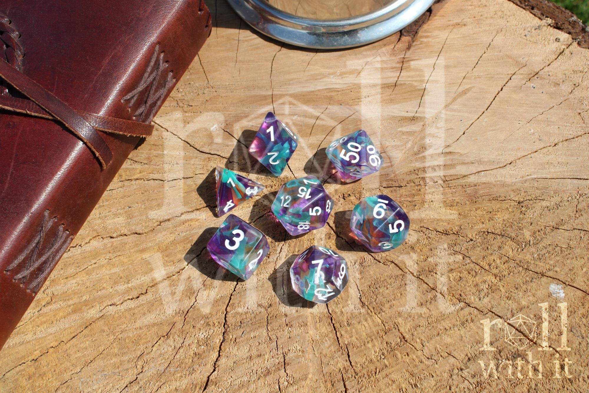 Set of 7 colourful aquamarine blue, lilac and ginger toned multicoloured polyhedral DND roleplaying dice with white numbers on a wooden surface
