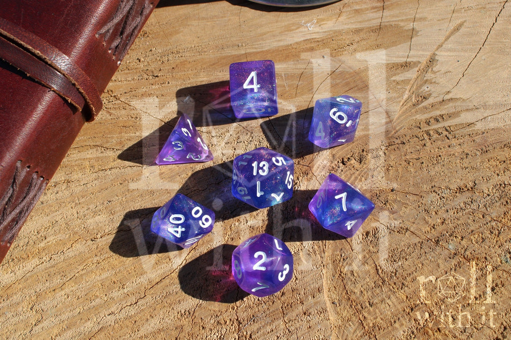 Set of glittery indigo purple polyhedral roleplaying dice with white numbers on a wooden surface
