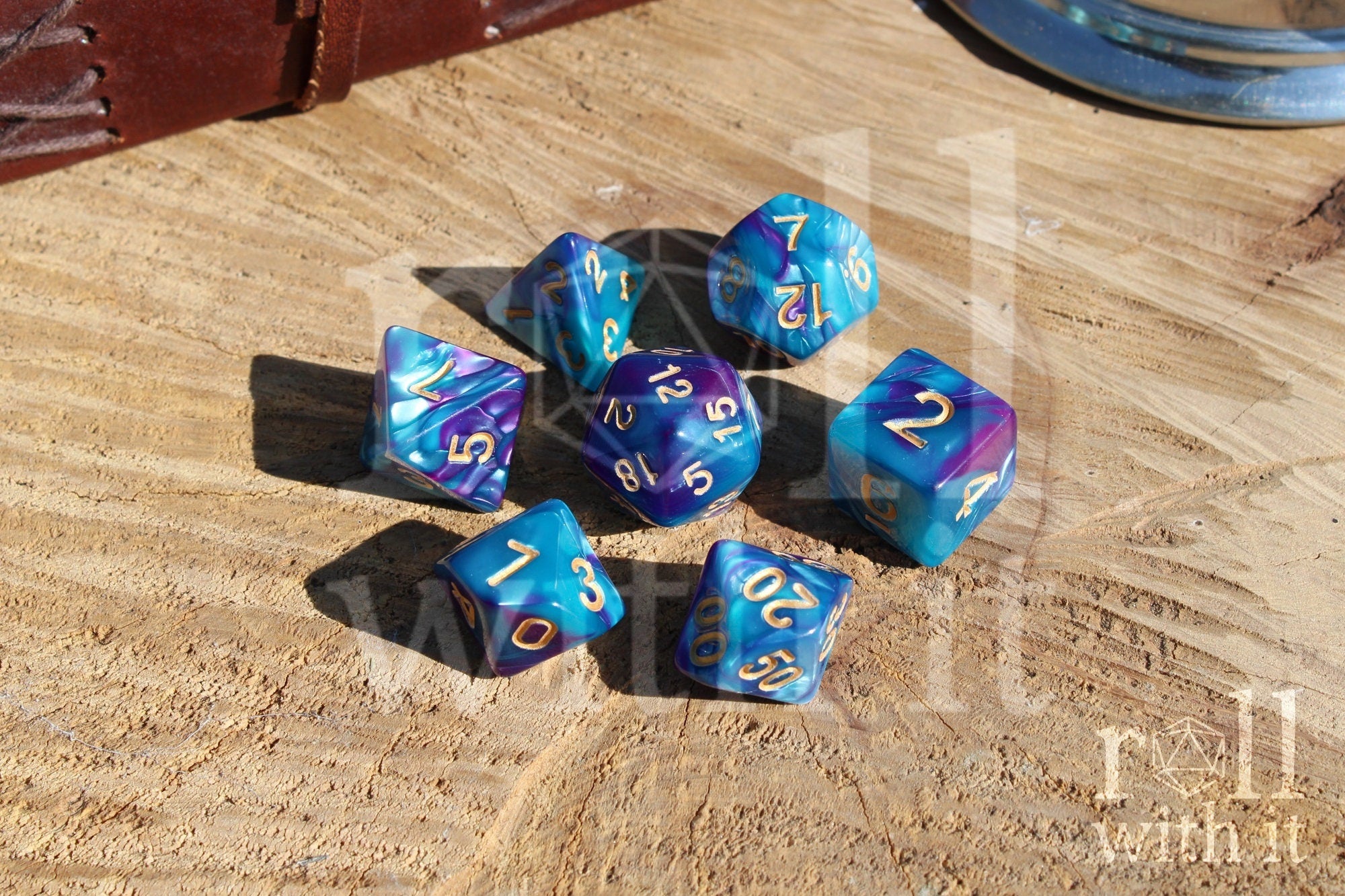 A set of colorful purple and blue polyhedral dice with golden numbers on a wooden surface