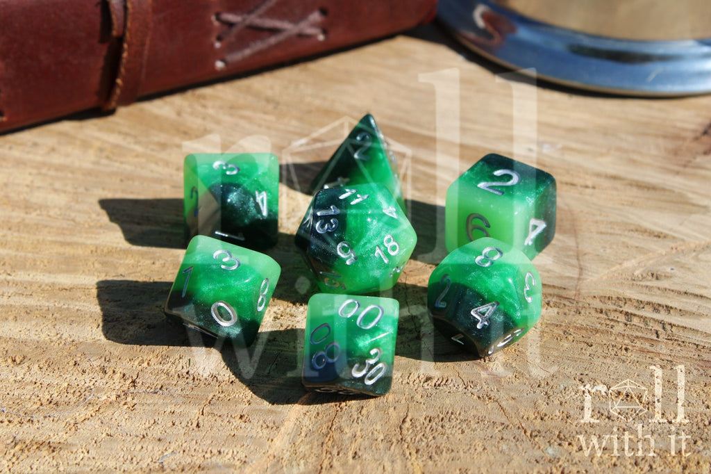 Green and black glittery polyhedral DND dice set on a wooden surface