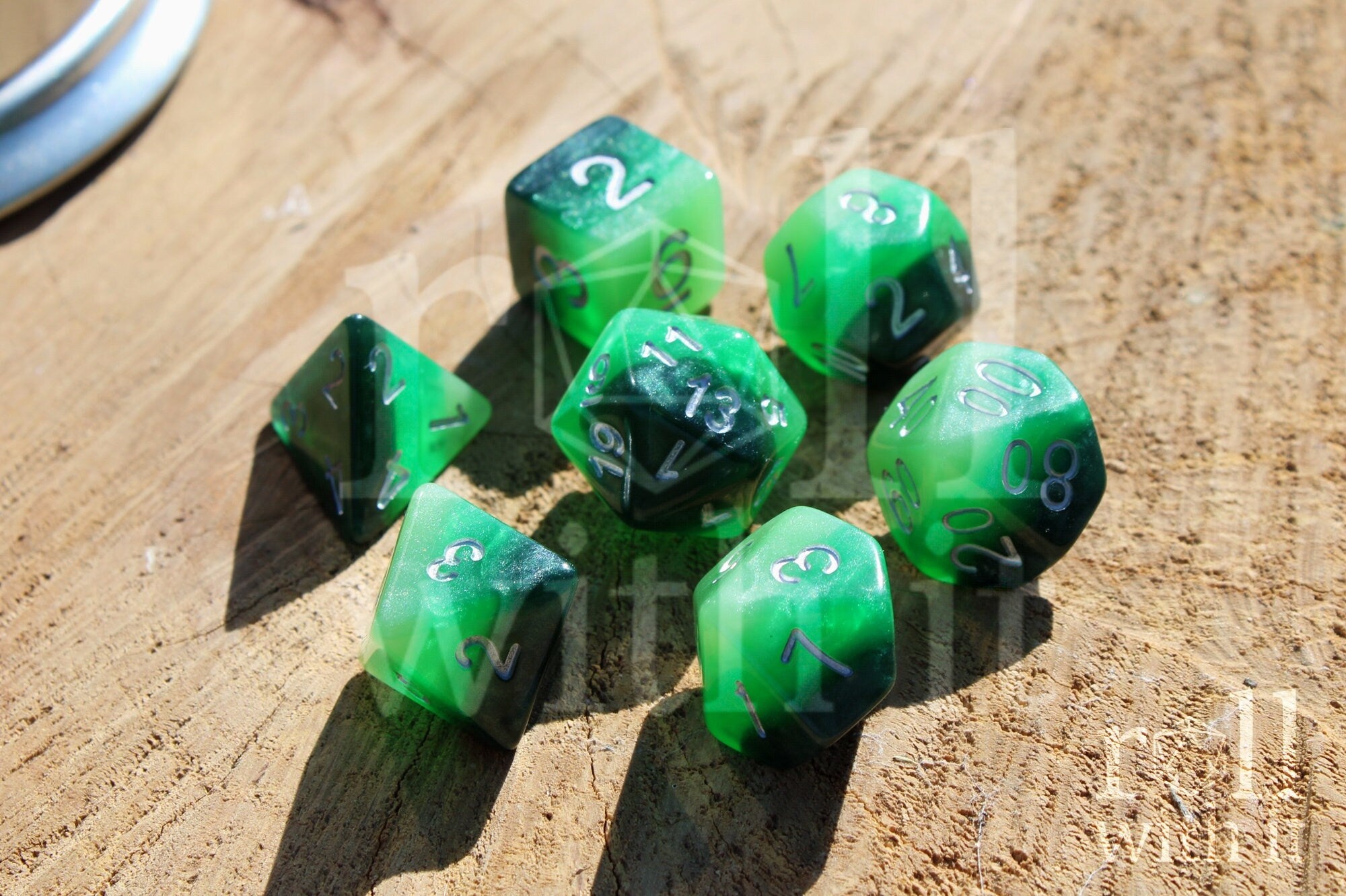 Green and black glittery polyhedral dice set on a wooden surface