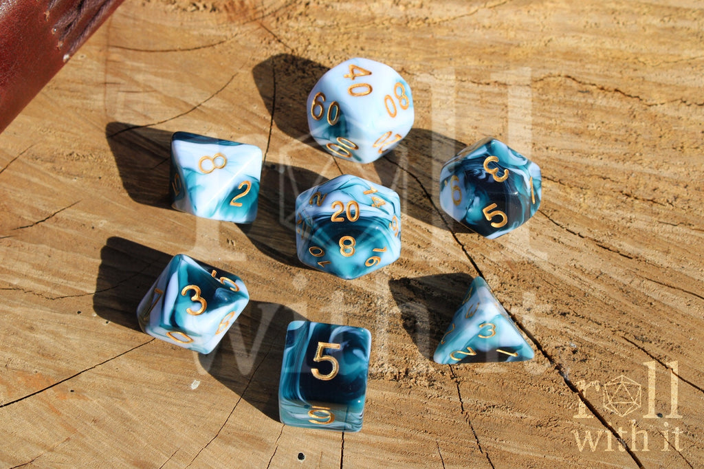 Set of white and blue swirling roleplaying dice with gold numbers on a wooden surface