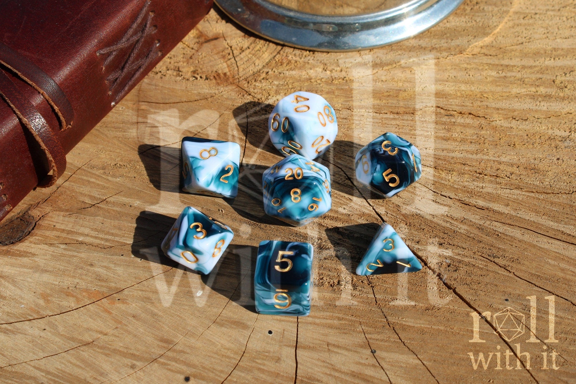 Set of blue and white marbled polyhedral dice with gold numbers on a wooden surface with tabletop gaming accessories in the background