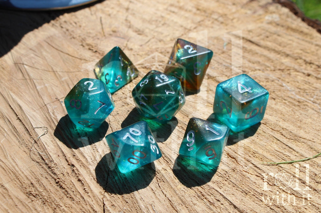 Set of turquoise blue and copper glittery polyhedral dice with white numbers on a wooden surface