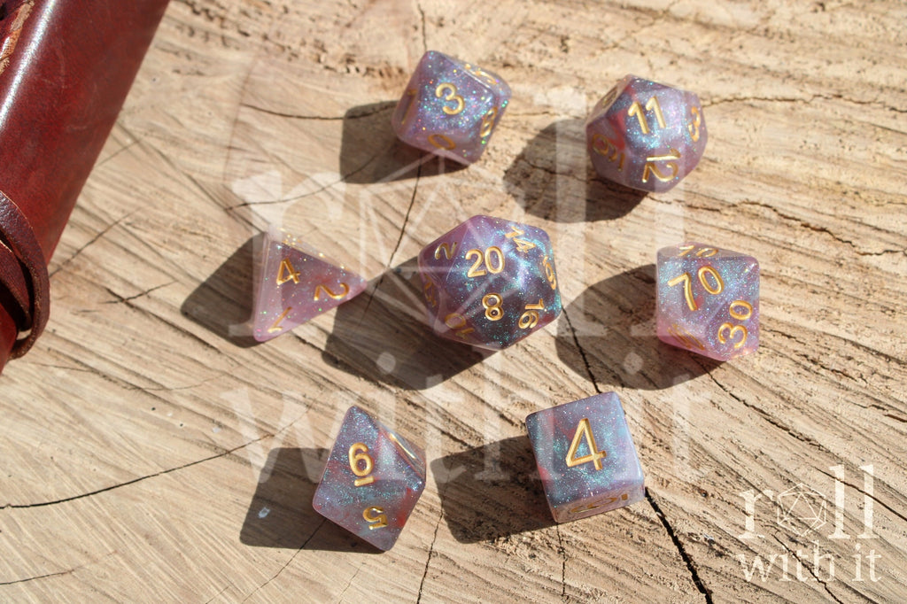 Set of glittery star like purple and blue polyhedral dice on a wooden surface