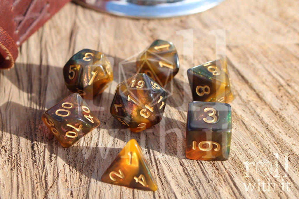 Set of 7 glittery pink, green, smoky amber and orange swirling polyhedral roleplaying dice on a wooden surface.