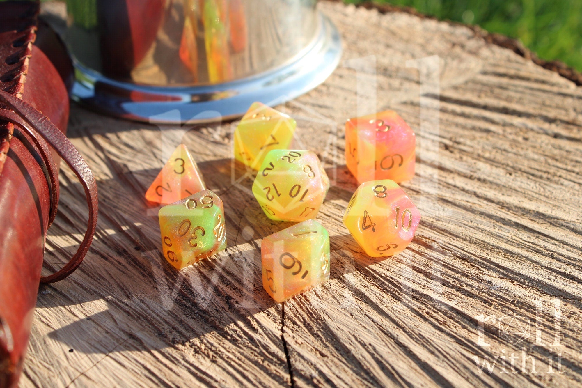 Set of colourful glittery light green and peachy pink polyhedral dice on a wooden surface