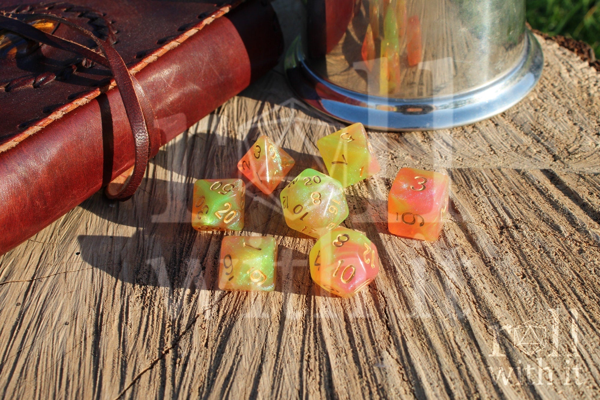 Set of colourful glittery light green and peachy pink polyhedral dice on a wooden surface