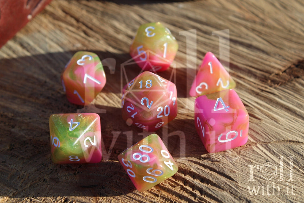 Set of colorful pink and green with glitter polyhedral dice on a wooden surface