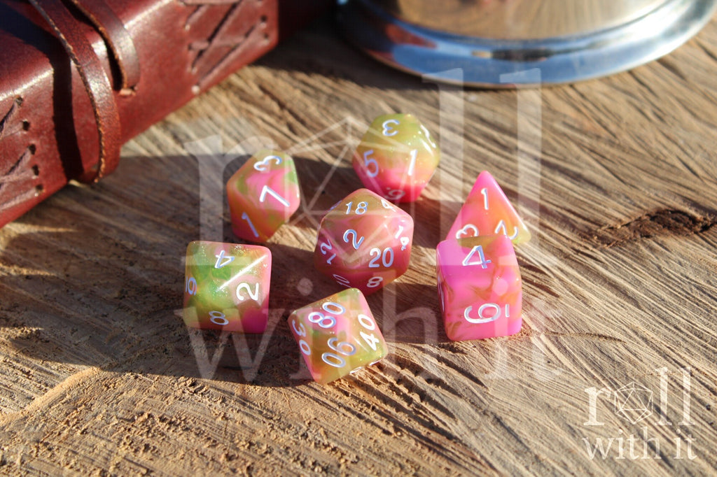 Set of candy pink and green with glitter polyhedral dice on a wooden surface