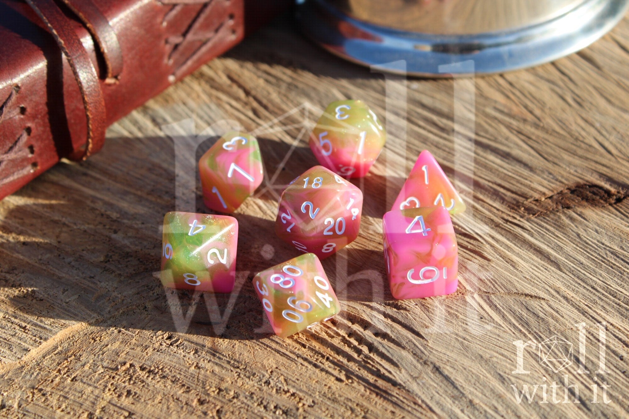 Set of candy pink and green with glitter polyhedral dice on a wooden surface