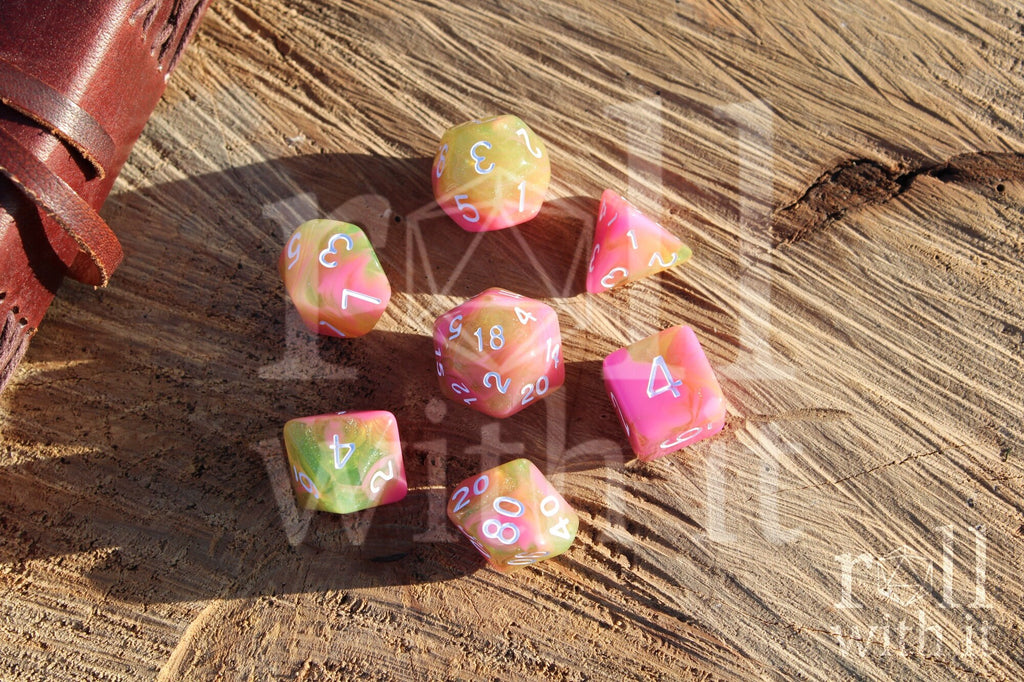 Set of candy pink and green with glitter polyhedral dice on a wooden surface