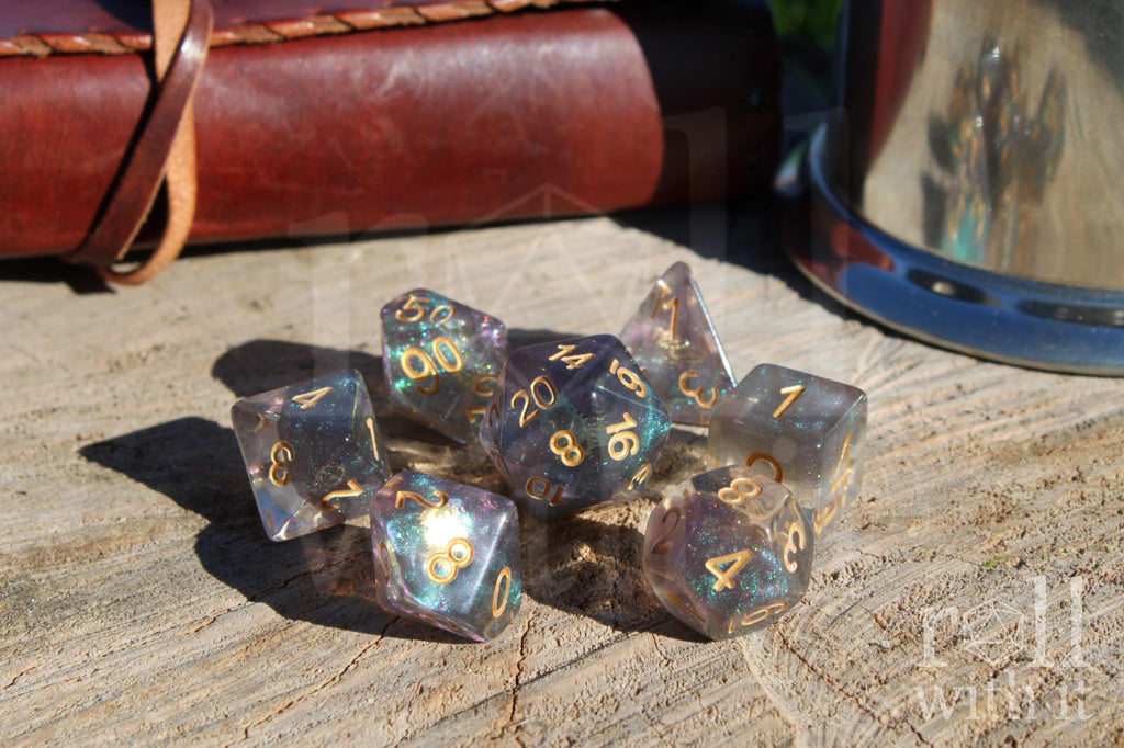 Set of glittery and star like dice with gold numbers and golden cogs inside on a wooden surface