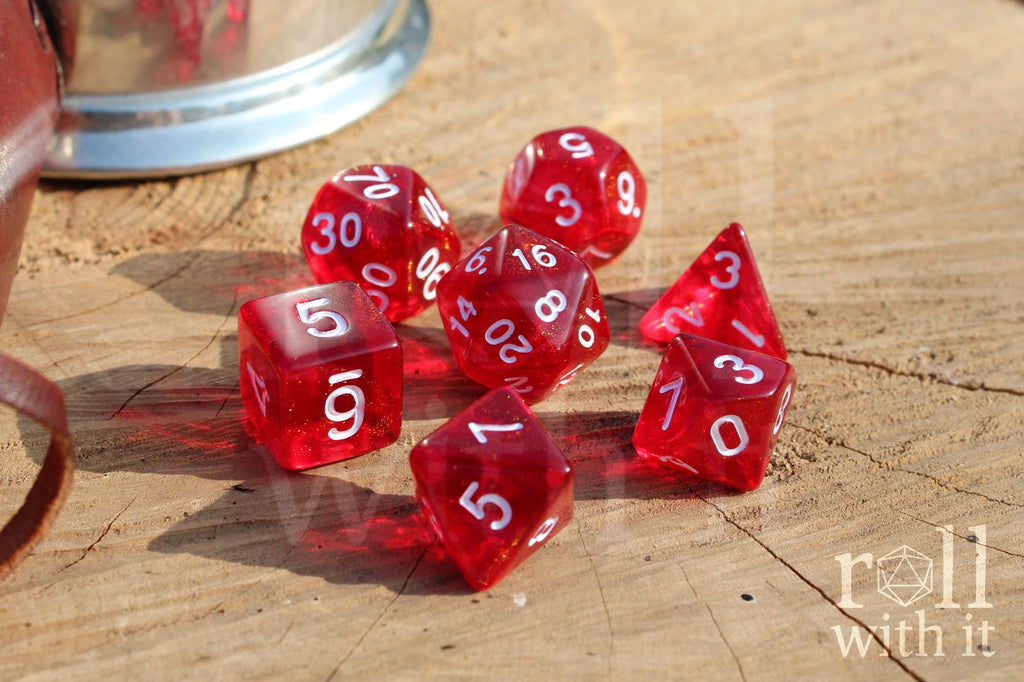 Scarlet red glittery polyhedral roleplaying dice with white numbers on a surface