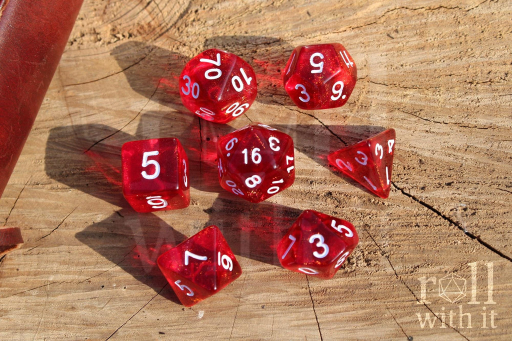 Scarlet red glittery polyhedral roleplaying dice with white numbers on a surface