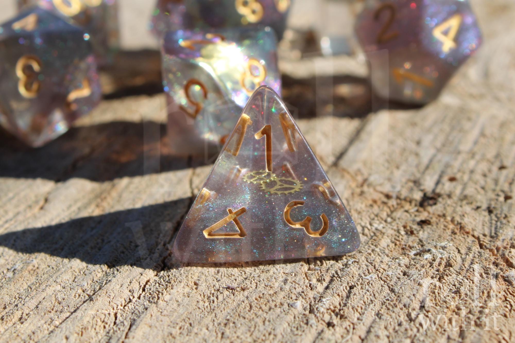 Set of glittery and star like dice with gold numbers and golden cogs inside on a wooden surface