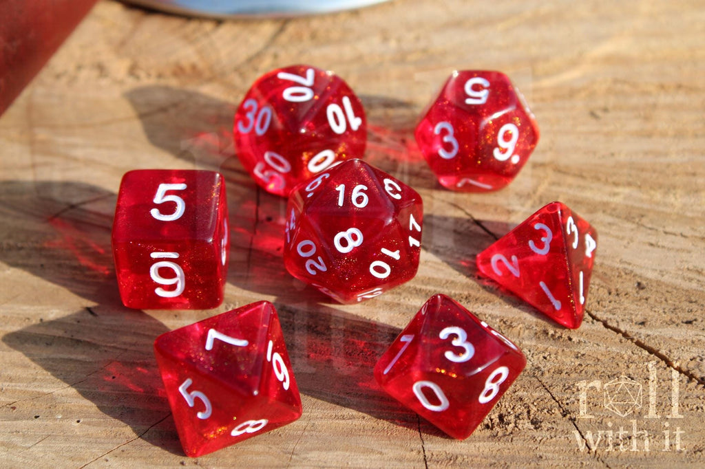 Scarlet red glittery polyhedral roleplaying dice with white numbers on a surface