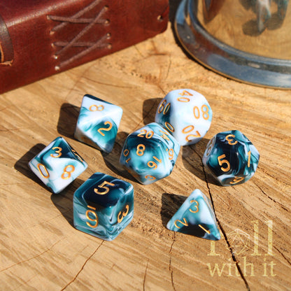 Set of blue and white dice with gold numbers on a wooden surface, featuring the text 'roll with it'.