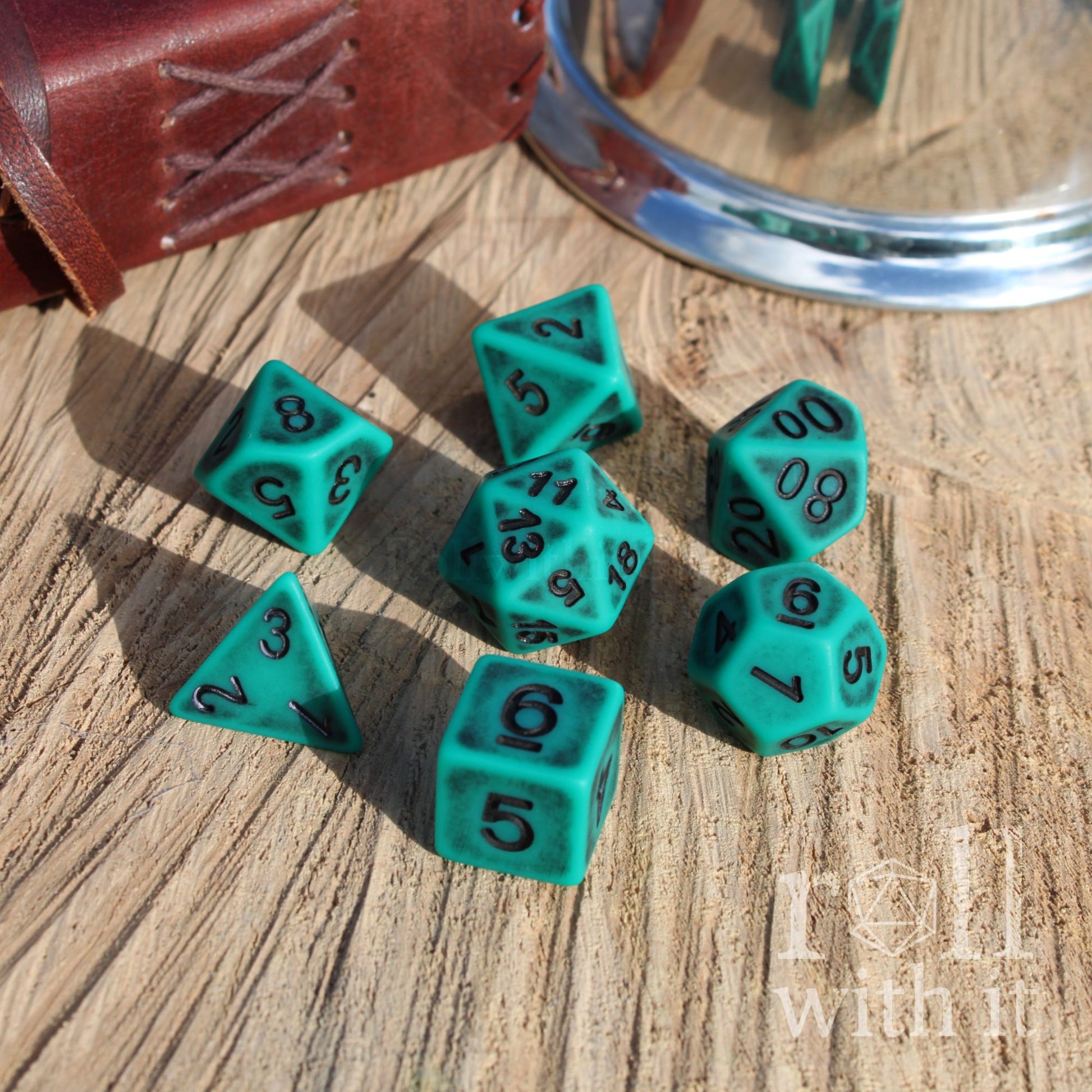 set of 7 turquoise matte worn DND dice on a wooden surface