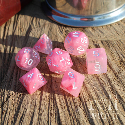 A set of 7 cute pink cloudy aesthetic polyhedral RPG on a wooden surface with white numbers