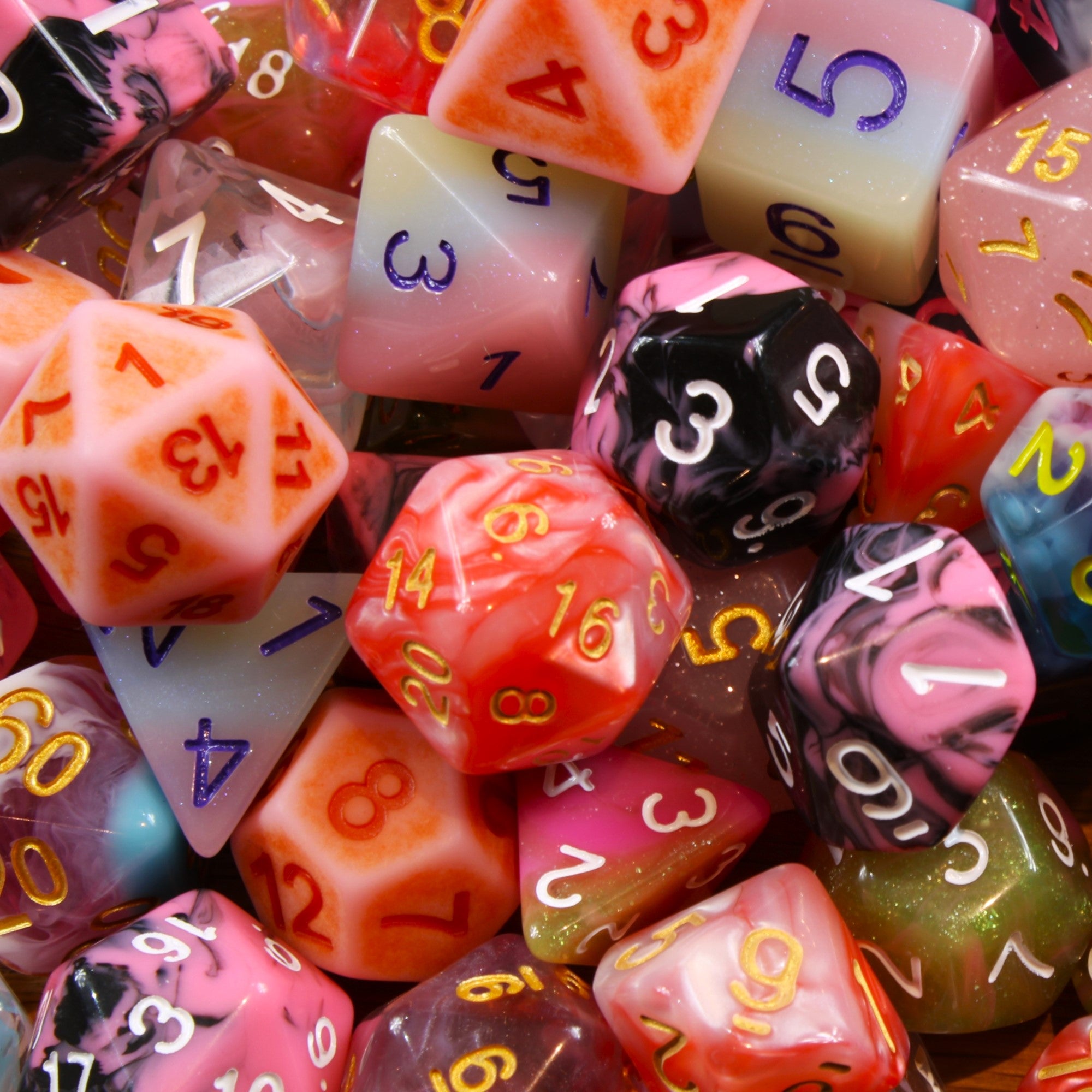 Assorted pink polyhedral roleplaying dice with numbers on a close-up shot