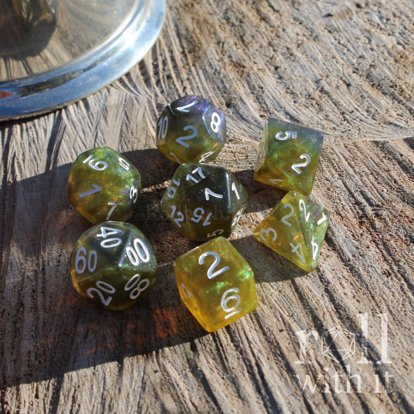 Set of green blue yellow glittering shiny polyhedral dice on a wooden surface